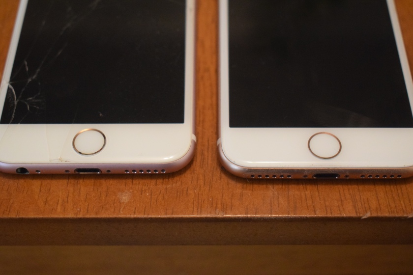 Photo of the bottom of two phones side by side, showing home button